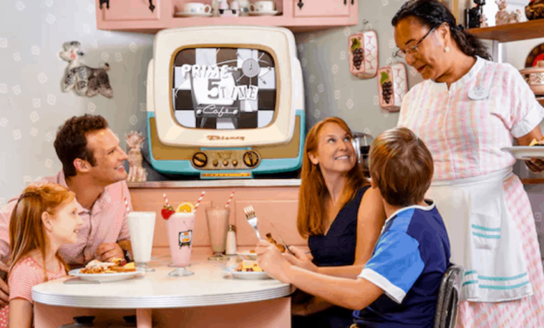 A family of four, including two children, is seated in a retro-style diner with pastel decor. They are being served by a waitress in a pink and white uniform. A vintage TV displaying black-and-white content is in the background.