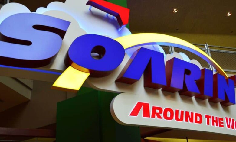Soarin' Around the World entrance sign with clouds and a yellow arc at Epcot, welcoming thrill-seekers and Disney fans. Soarin’ Across America EPCOT opening date