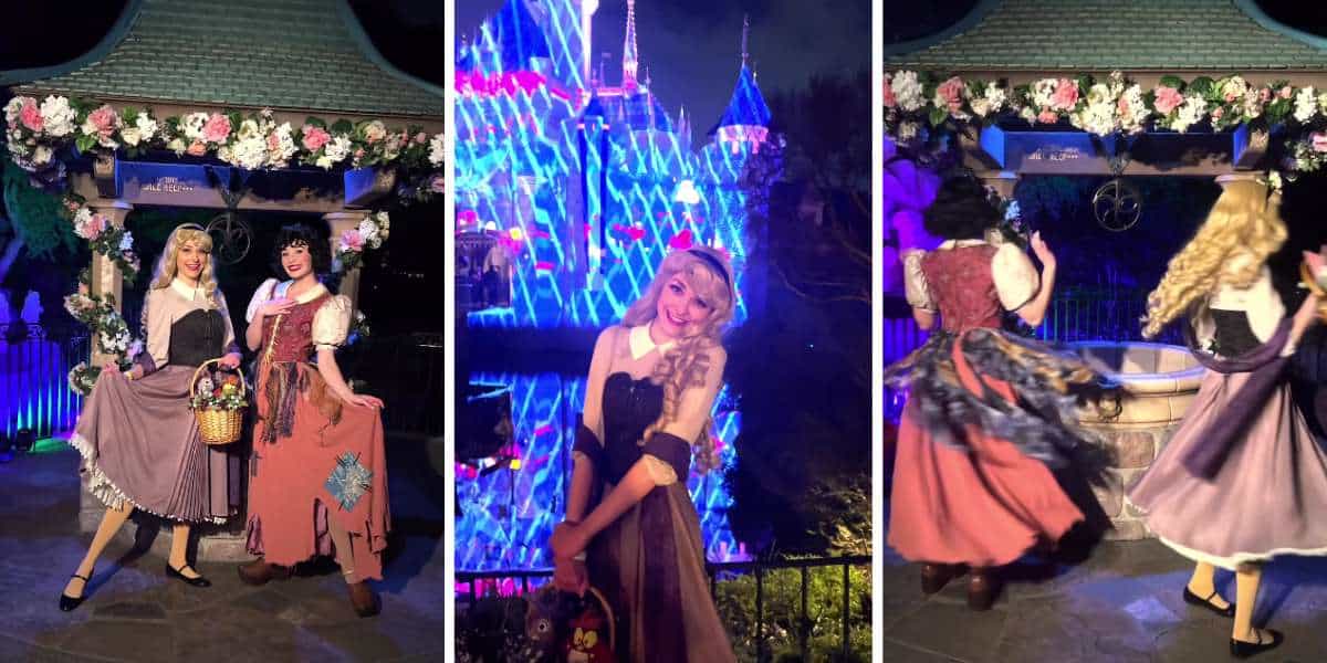 two women dressed as peasant versions of disney princesses snow white and aurora stand beside a wishing well and sleeping beauty castle