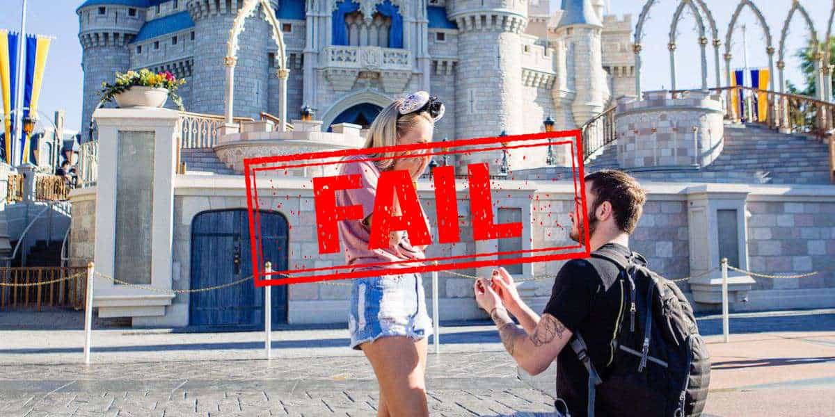 A white man with dark hair in black proposes on one knee to a white blonde woman with a pink top in front of cinderella castle with FAIL in red text