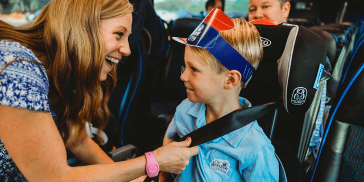 woman helps little boy with his seat belt