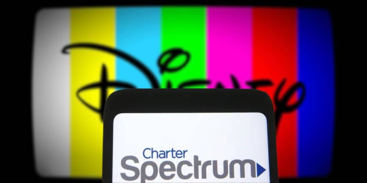 cell phone with spectrum logo and tv screen disney logo in background