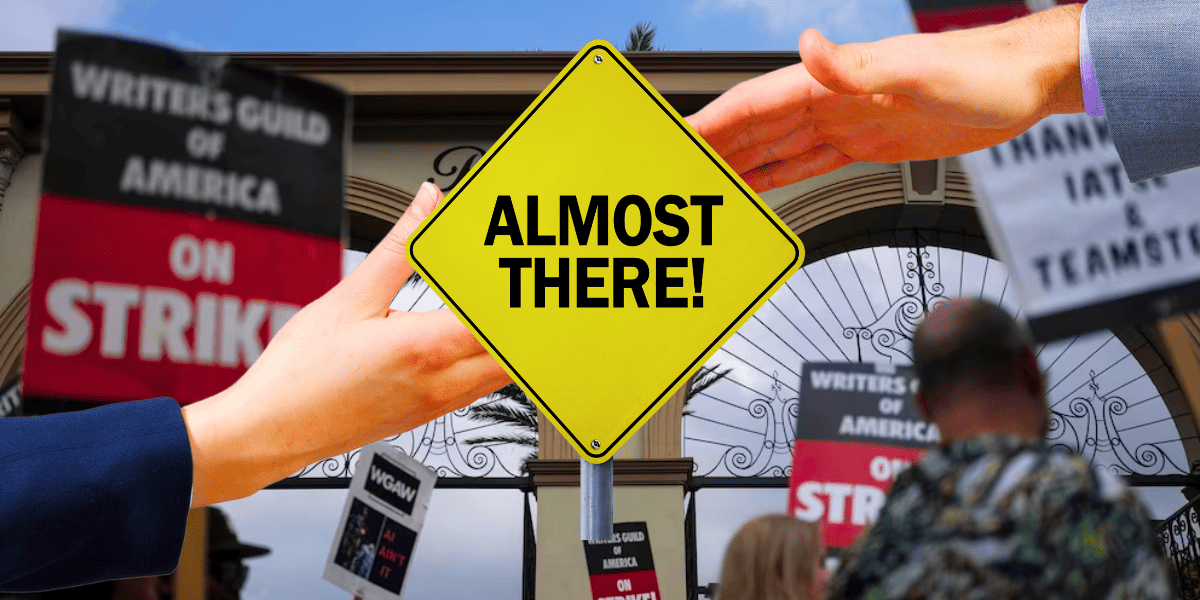 writers strike and two hands reach out to shake with "almost there" sign