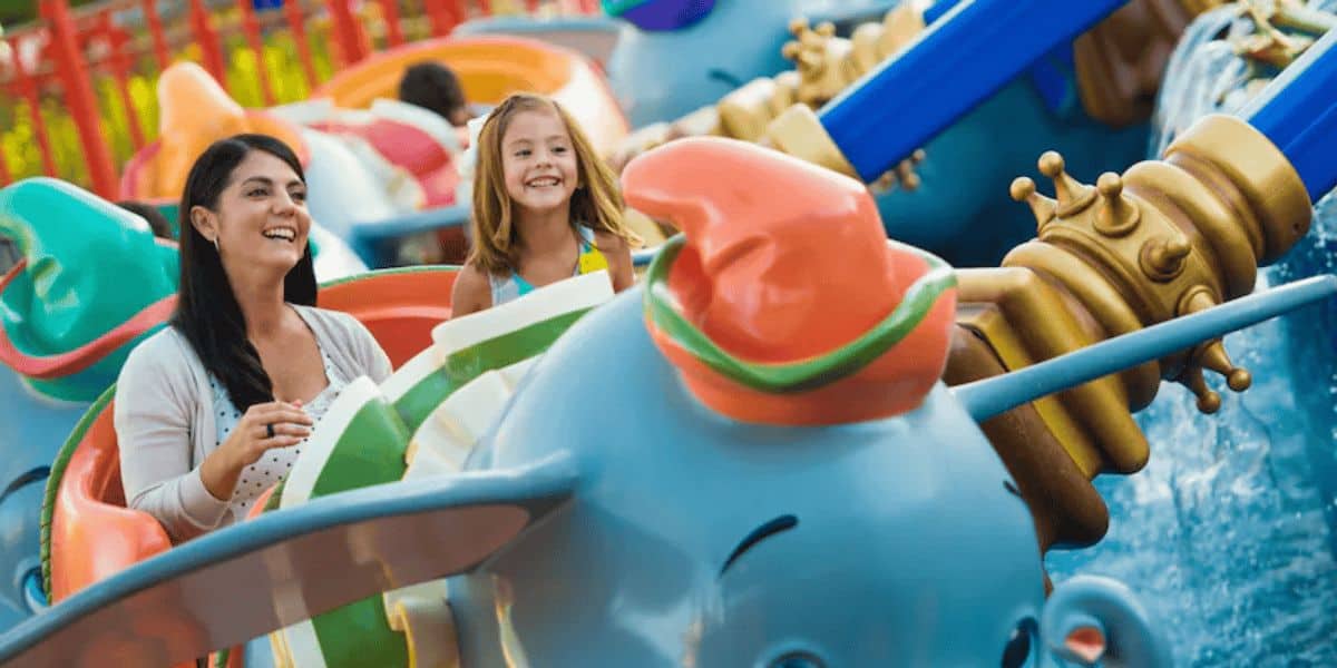 A woman and young girl ride Dumbo
