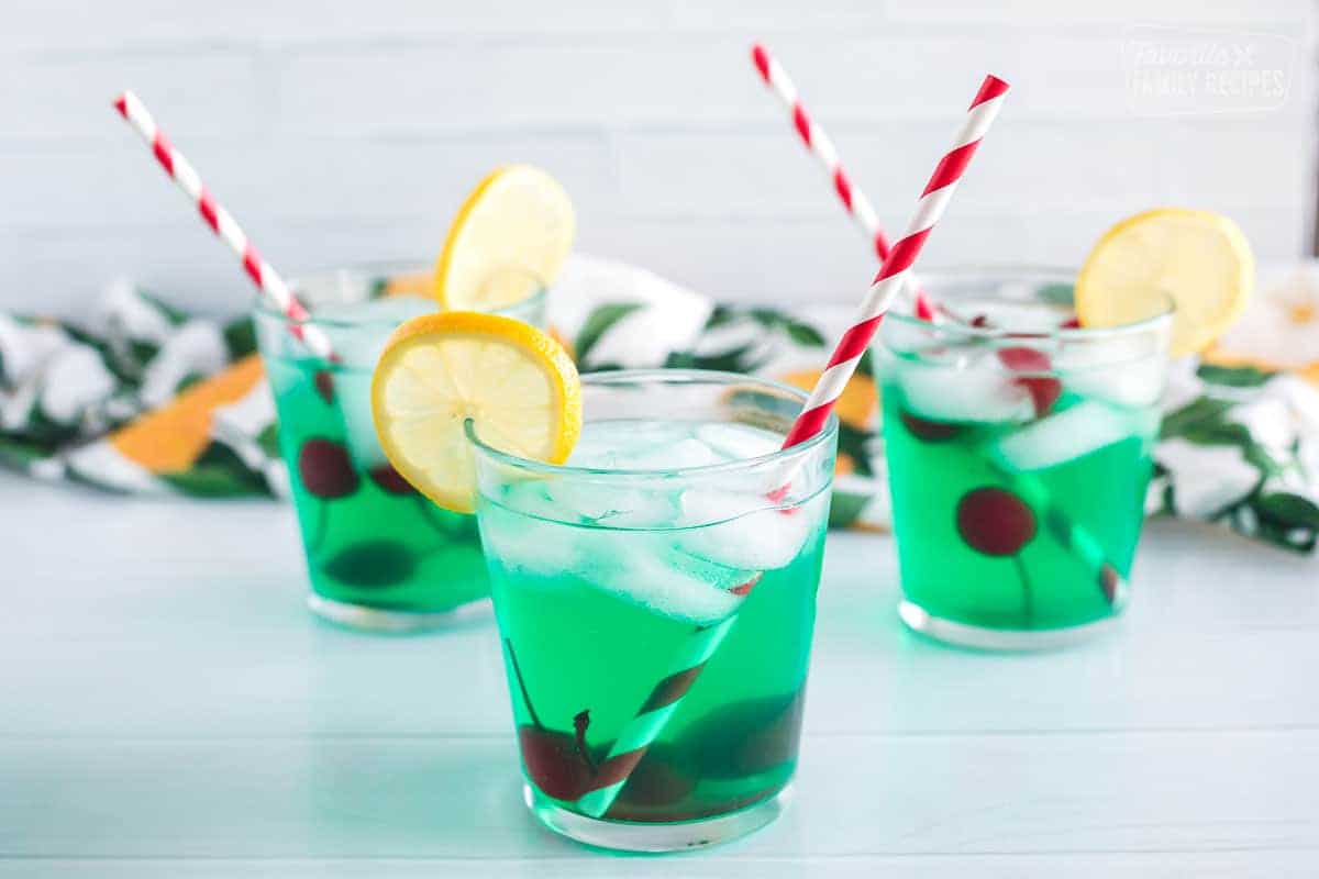 Three cups of mint juleps with cherries and lemon slices