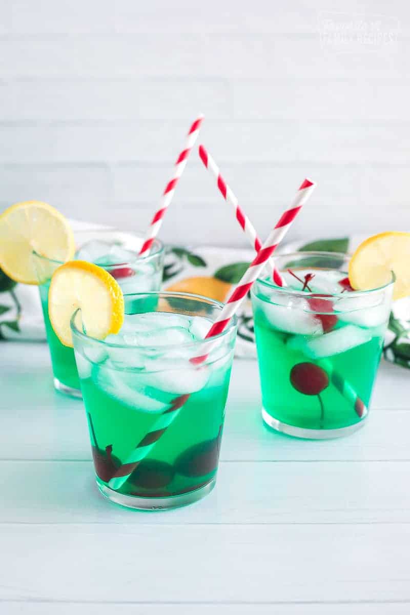 Three cups of mint juleps with cherries and lemon slices