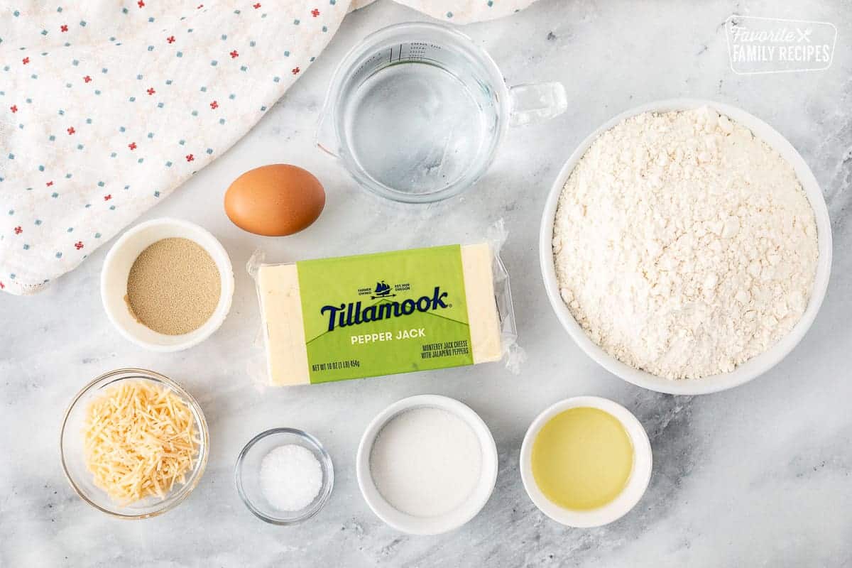 Ingredients to make Jalapeno Cheese Stuffed Pretzels including flour, water, Pepper Jack cheese, egg, yeast, parmesan cheese, salt, sugar and oil.