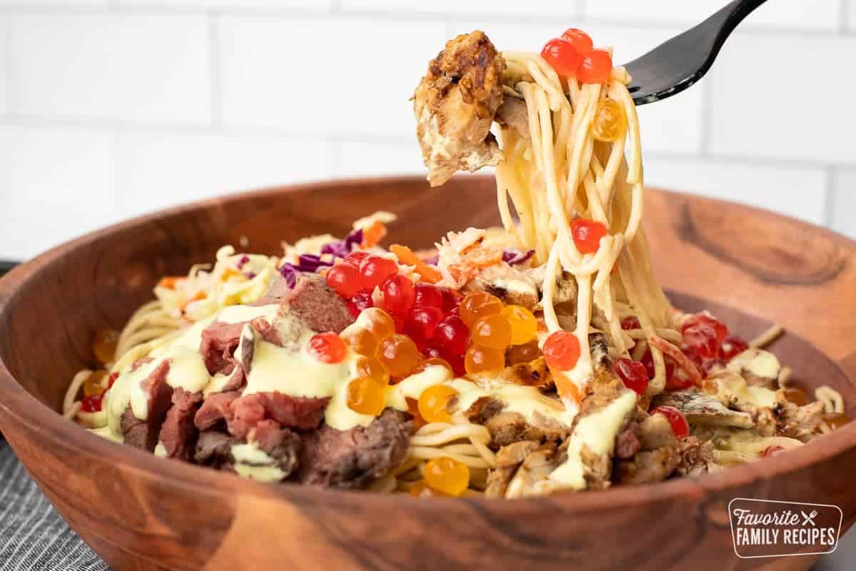 A fork pulling up noodles from a Satu'li bowl
