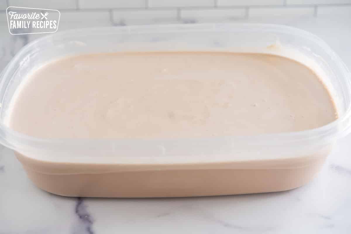 Cool whip, sweetened condensed milk, chocolate syrup, and milk in a large plastic container
