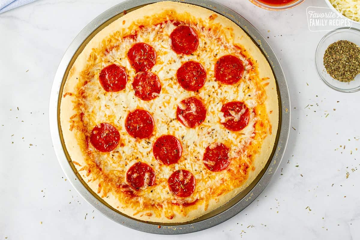 Whole baked Pizza with Homemade dough on a pizza dish.