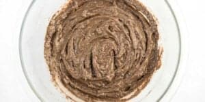 A top view of a glass bowl containing Grey Stuff recipe batter with a swirl pattern, placed on a white surface.