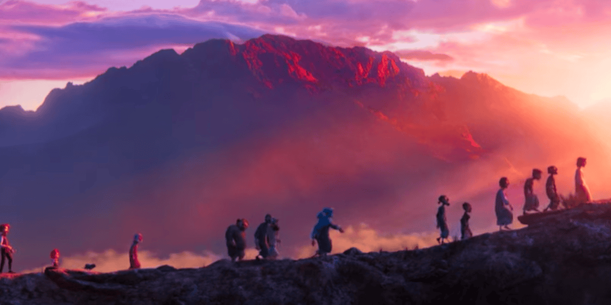 A line of animated characters, including children and adults, walk up a rugged mountain path. The backdrop features a large, majestic mountain bathed in the pink and purple hues of a setting sun. The sky is partly cloudy, enhancing the serene and adventurous scene.