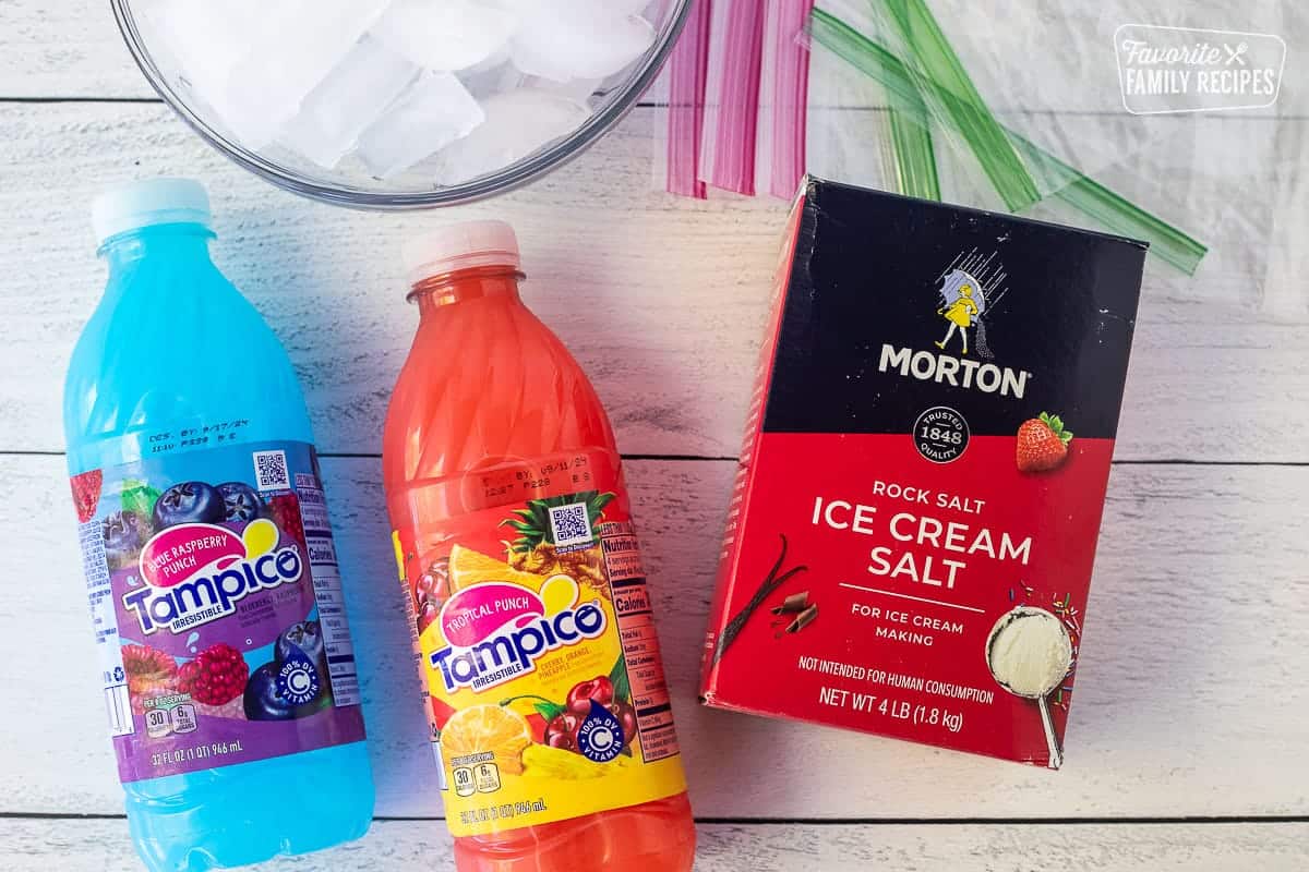 Ingredients for How to Make a Slushie including blue and pink juice, ziplock bags, ice and rock salt.