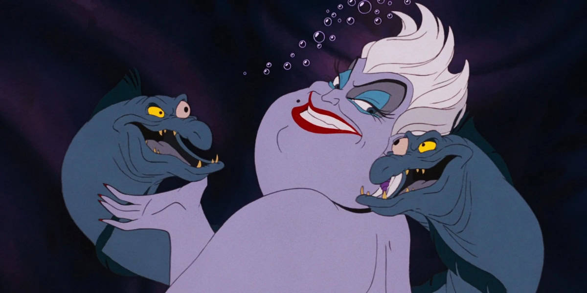 An animated character with pale purple skin and white hair, smiling wickedly with red lips and heavy blue eye shadow. She's flanked by two eel-like creatures with yellow eyes and menacing expressions. Bubbles rise around them, set against a dark background.