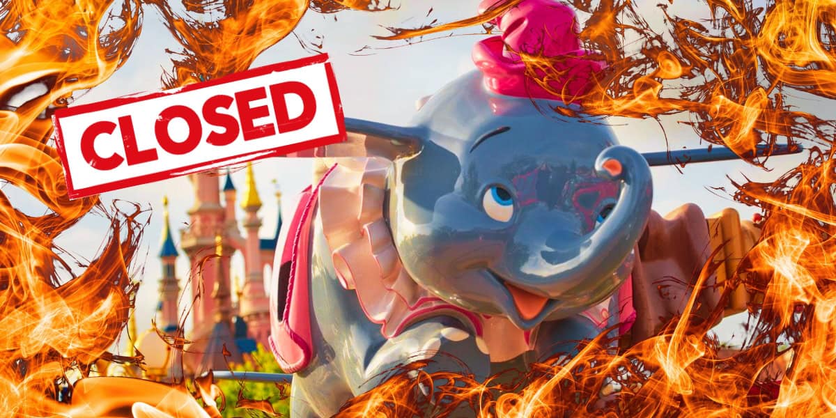 A colorful amusement park ride featuring a large gray elephant with big ears, a hat, and a playful expression is surrounded by dramatic flames. A red "CLOSED" sign is prominently displayed over the image, evoking an eerie sense of death at Disney. A fairytale castle is visible in the background.