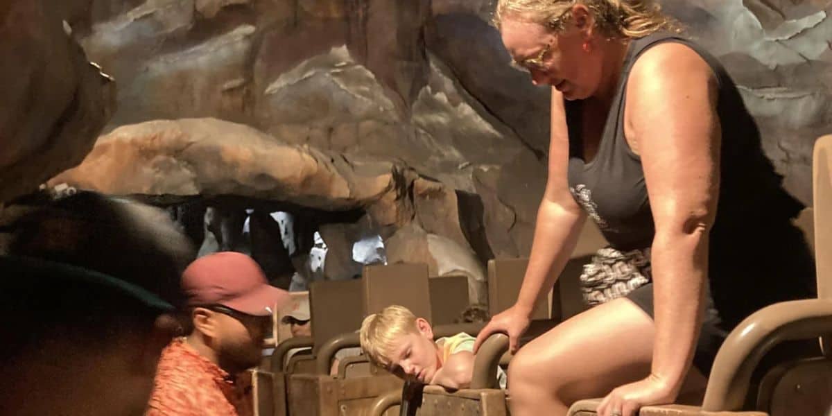 A woman climbs out of Expedition Everest.