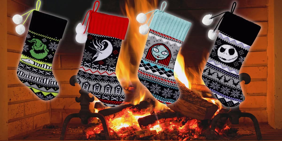 Four festive Christmas stockings hang by a cozy fireplace. Each stocking is uniquely designed with characters and patterns, enhancing the warm and festive atmosphere of the room.