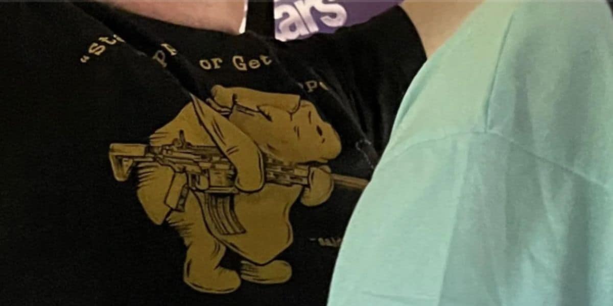 A close-up of a man wearing a shirt of Pooh with a gun, which some fans felt violated the Disney dress code.