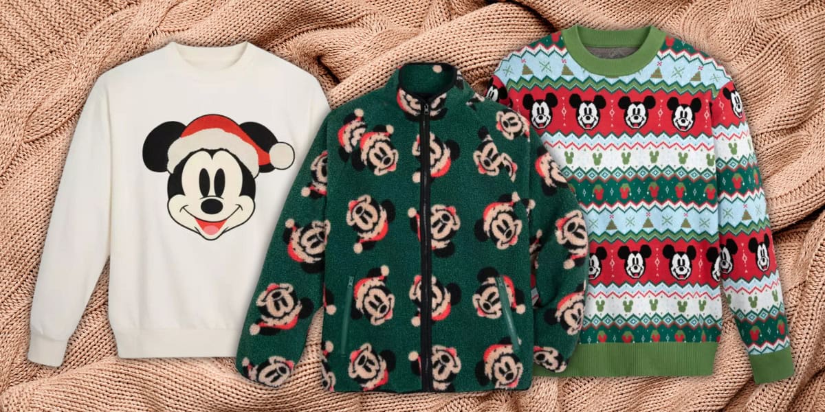 Three sweaters are displayed on a knitted beige background. The first is white with a Mickey Mouse face wearing a Santa hat. The second is a green fleece with Mickey wearing Santa hats. The third is a festive sweater with a Mickey Mouse pattern and green trim.