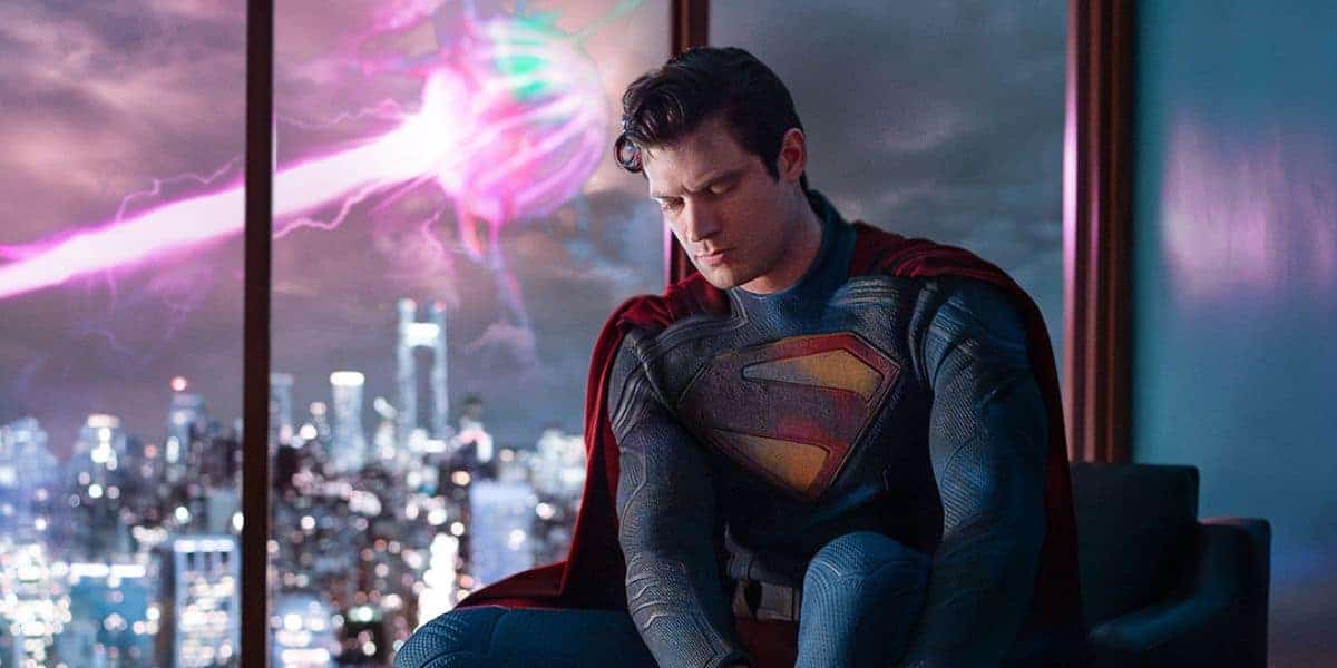 Superman (David Corenswet) putting on his boots in front of a light in the sky.