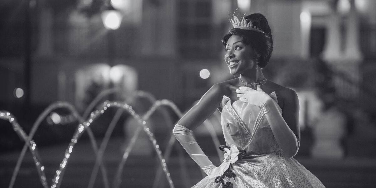 Princess Tiana in front of a fountain in black & white.