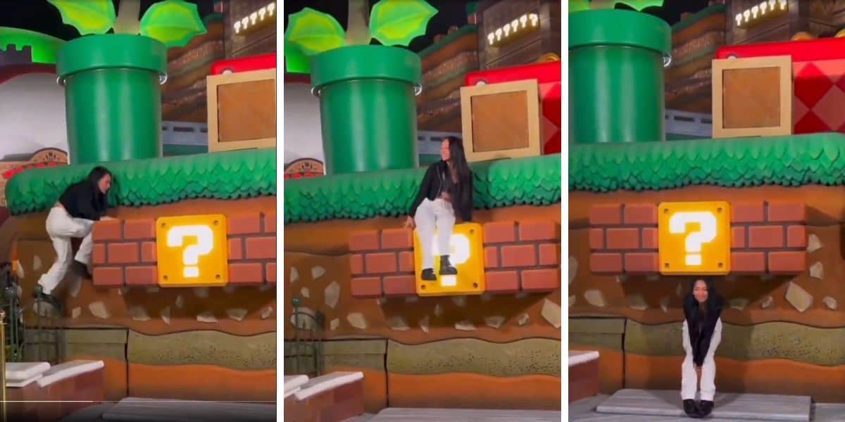 A person climbs onto a Super Mario-themed question block, sits on it, and then crouches down. The background features iconic green pipes and game elements.