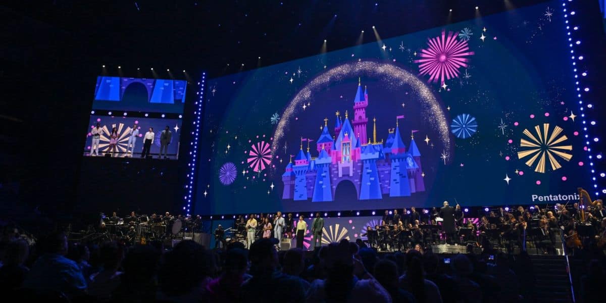 A large stage features a grand digital display of a Disney castle at D23