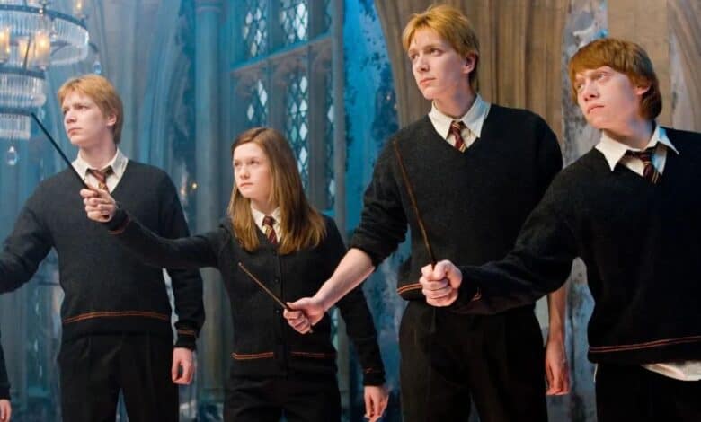Fred, George, Ginny, and Ron holding out their wands