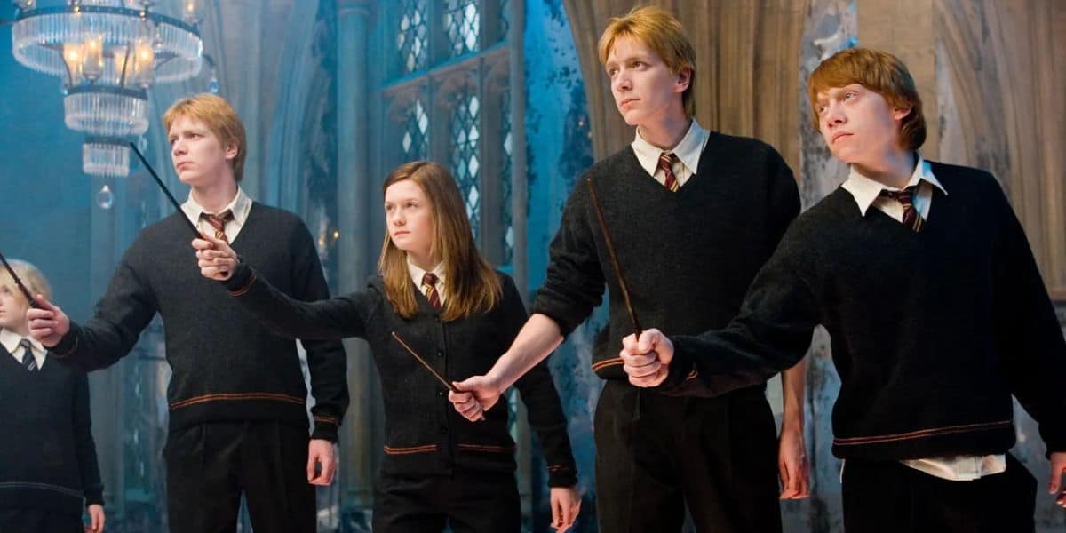 Fred, George, Ginny, and Ron holding out their wands
