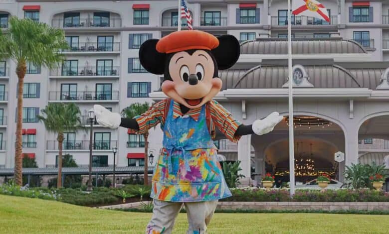 Mickey Mouse in an artists outfit in front of Disney World Resort's Riviera Resort with guests inside as Disney World vacations change.