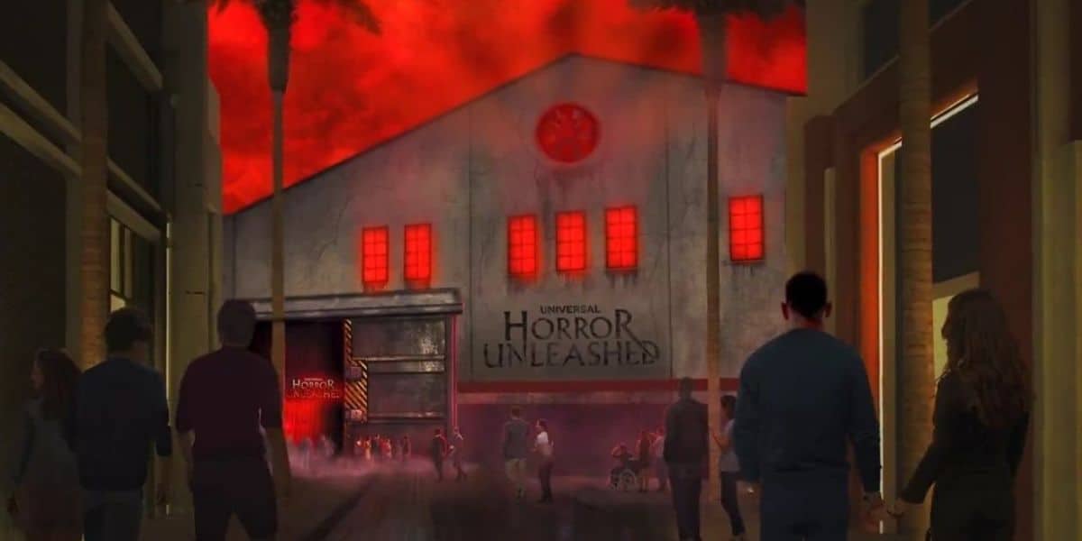 People walk toward a haunted house attraction titled "Universal Horror Unleashed." The building has a spooky, red-lit exterior with glowing windows and eerie fog. The sky above is ominously red, enhancing the horror theme at Universal Horror Unleashed.
