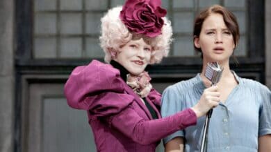 Effie Trinket holding the microphone in front of Katniss Everdeen