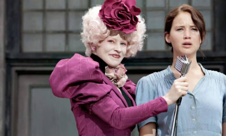 Effie Trinket holding the microphone in front of Katniss Everdeen