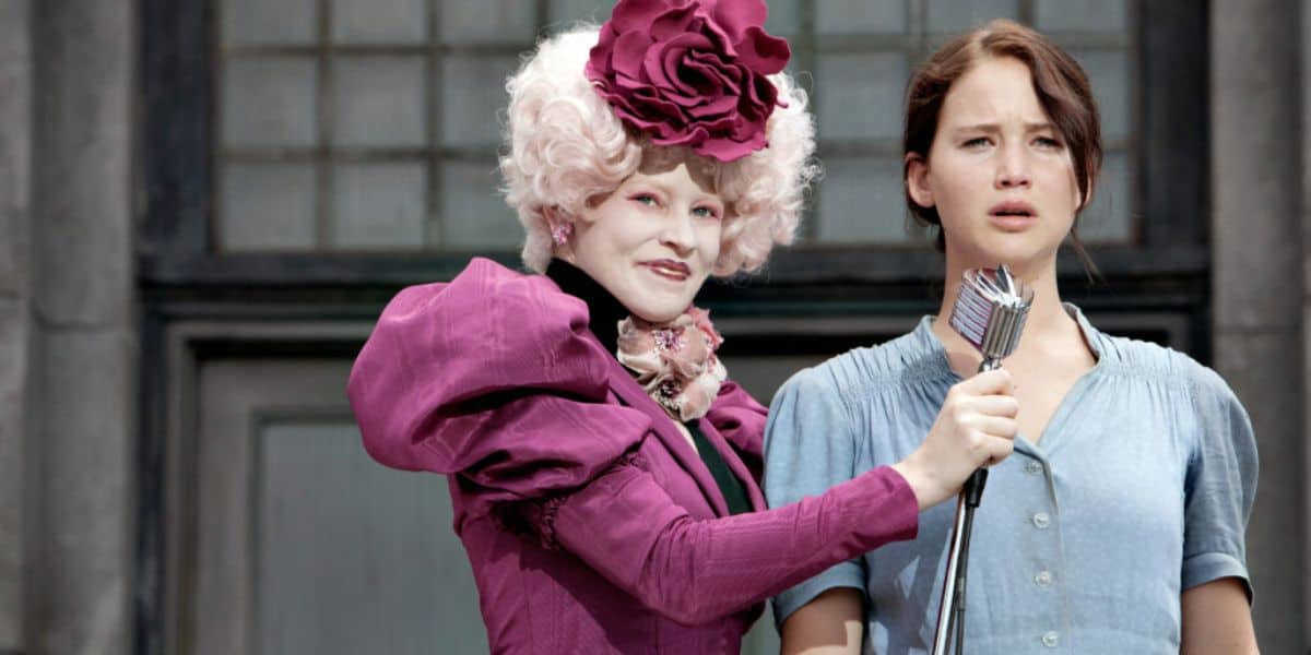 Effie Trinket holding the microphone in front of Katniss Everdeen