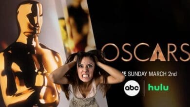 A frustrated woman in front of the promo image for the Oscars