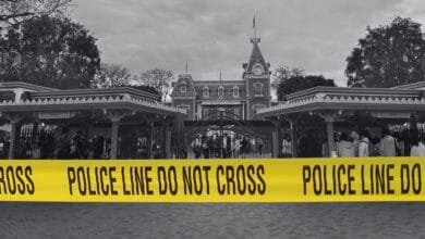 The entrance to Disneyland Park in black-and-white with police tape edited on top.
