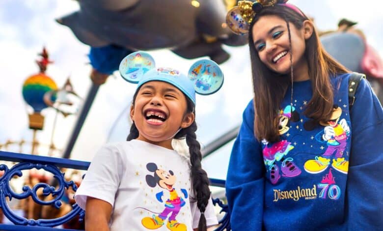 A teen girl and young girl wear Disneyland 70 merchandise