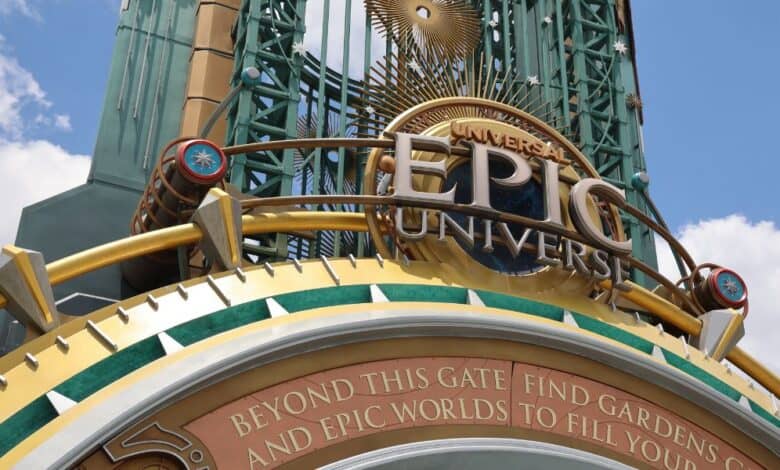 Large decorative entrance sign for Universal Epic Universe, featuring gold and green accents, a sunburst design, gears, and the words: “Beyond this gate find gardens and epic worlds to fill your soul.” as a possible new Universal expansion project could be going on.
