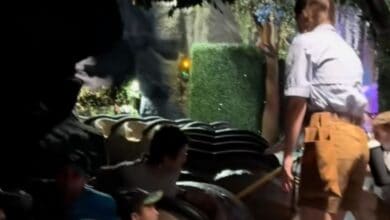 A Disney cast member helps evacuate families from Tiana's Bayou Adventure