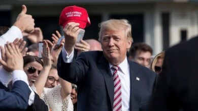 Donald Trump holds a MAGA hat as a Disney white house meeting took place in July.