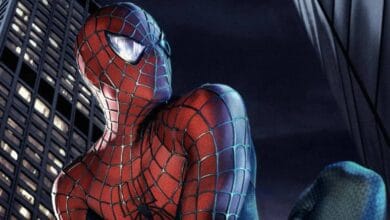 Spider-Man in his red and blue suit crouches on a building at night, looking over his shoulder with city skyscrapers and dark sky in the background.