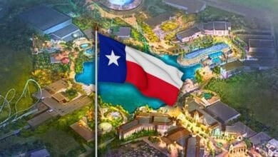 An illustrated aerial view of a theme park, with the Texas state flag prominently displayed in the center of the image. The park features winding pathways, rides, and brightly lit buildings at Universal Kids Resort.