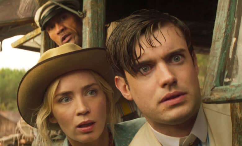 A woman in a tan hat and a man in a suit look out of a window with surprised expressions, while another man in a striped cap peers from behind them. They appear tense and curious, with greenery visible outside.