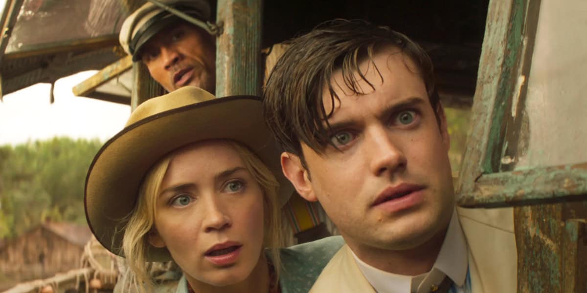 A woman in a tan hat and a man in a suit look out of a window with surprised expressions, while another man in a striped cap peers from behind them. They appear tense and curious, with greenery visible outside.