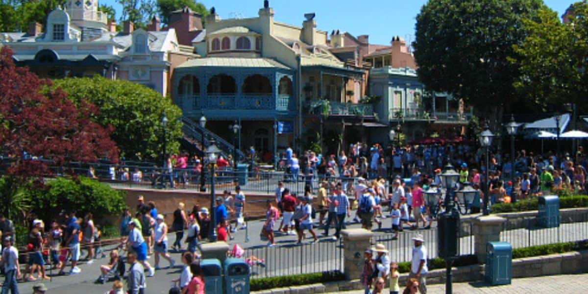 Crowds walking through New Orleans Square at Disneyland.
