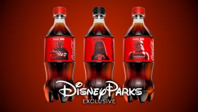 Three Coca-Cola bottles with exclusive Disney Parks Star Wars labels featuring characters: The Mandalorian, Darth Vader, and a Stormtrooper, on a red background with “Disney Parks Exclusive” text below.