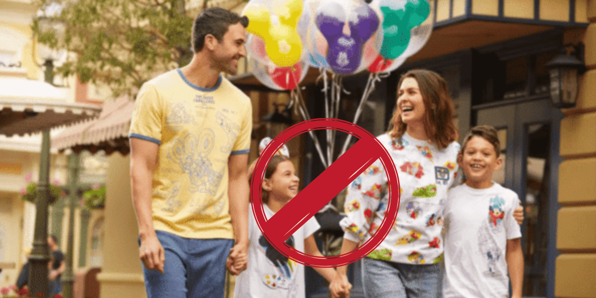 A smiling family of four walks outdoors holding hands, with colorful balloons in the background. A large red “no” symbol is overlaid on the image, partially covering the family.