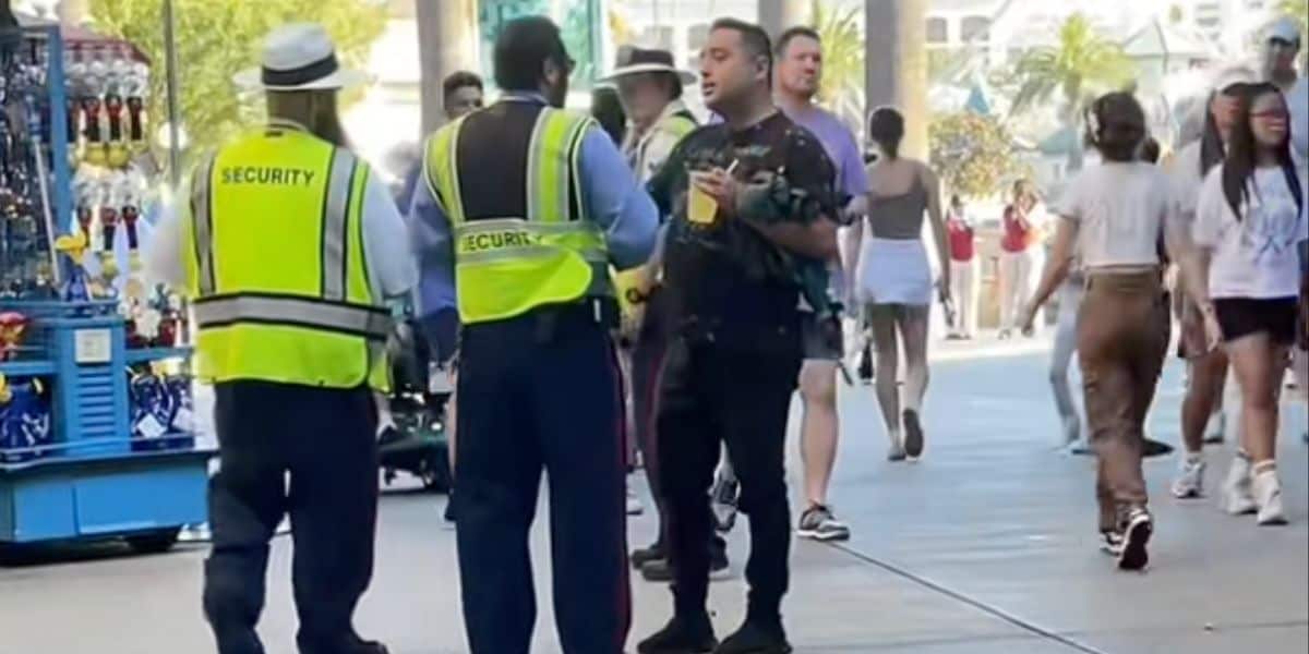 Disneyland Resort security talks to a man holding a drink at Disney California Adventure Park.