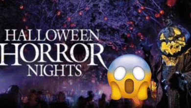 Halloween Horror Nights sign glows among eerie purple-lit trees, with a sinister jack-o’-lantern-headed figure in a dark cloak and a large shocked face emoji in the foreground.