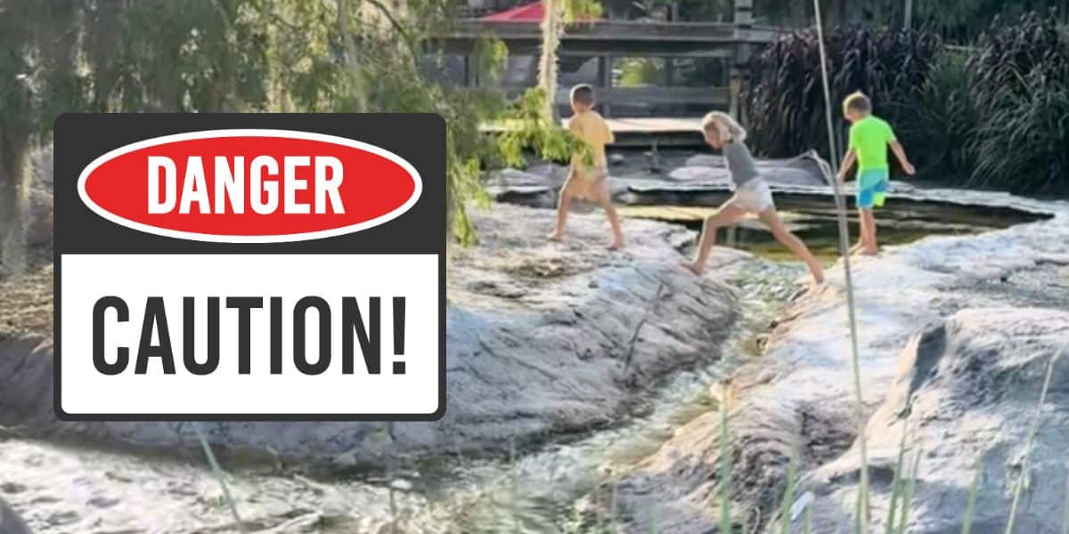 Three children walk barefoot on rocks near a body of water at Disney's Wilderness Lodge, sparking a debate about parenting at disney world.